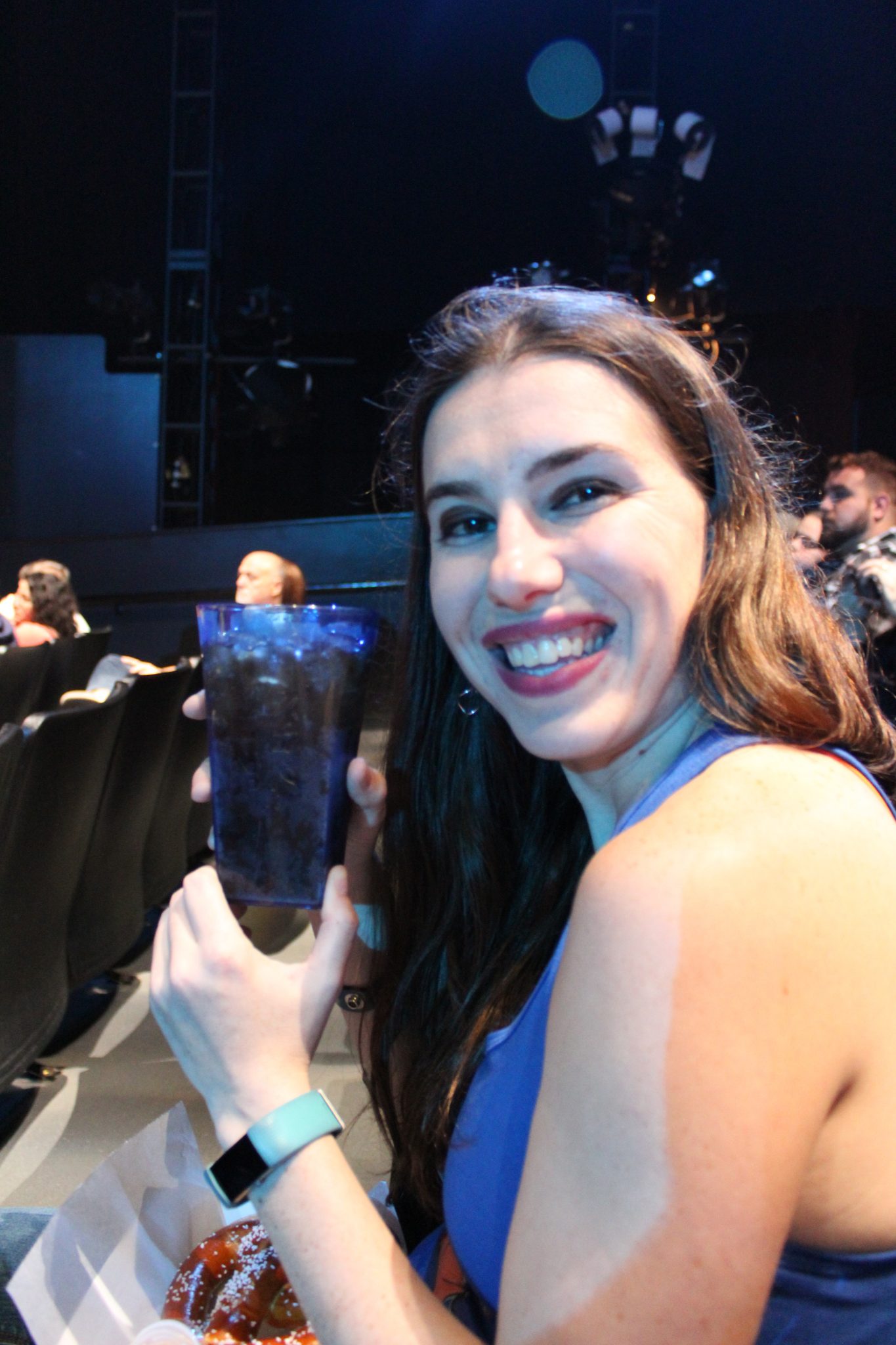 Chelsea sits in the Blue Man Group theater displaying her souvenir soda cup.