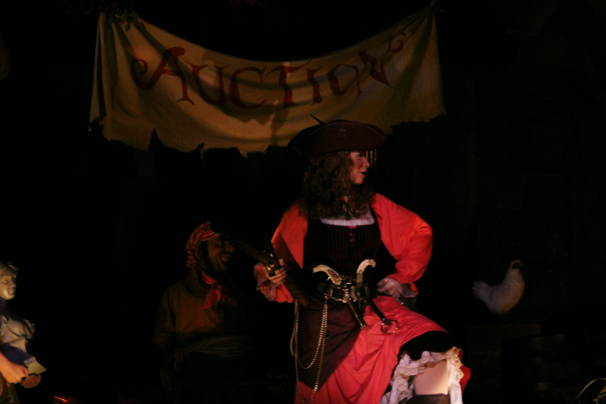 A profile shot of the Pirates of the Caribbean Red Head with "Auction" in the background.