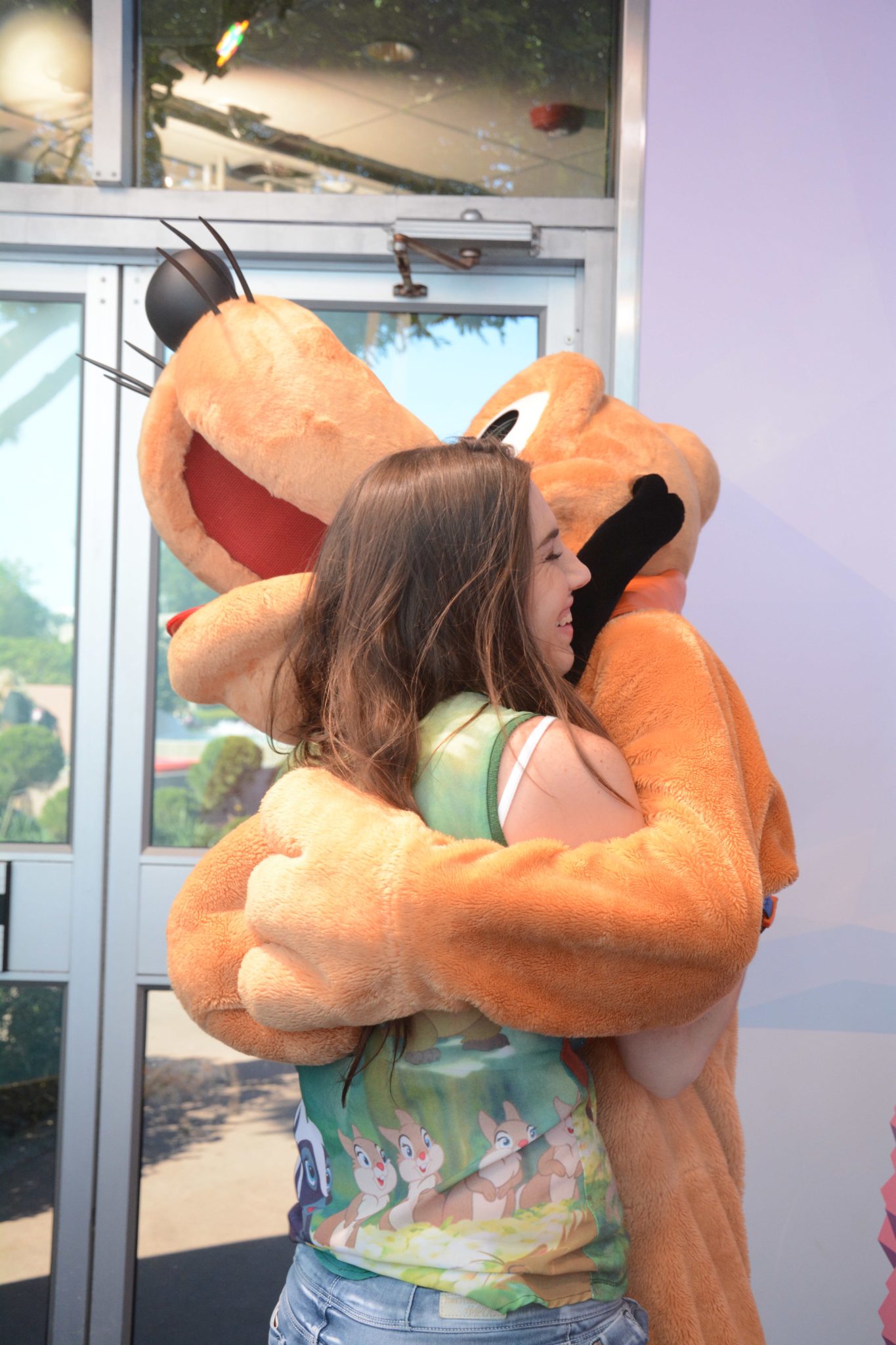 Chelsea gets a big hug from Pluto at the Visa Photo Spot.