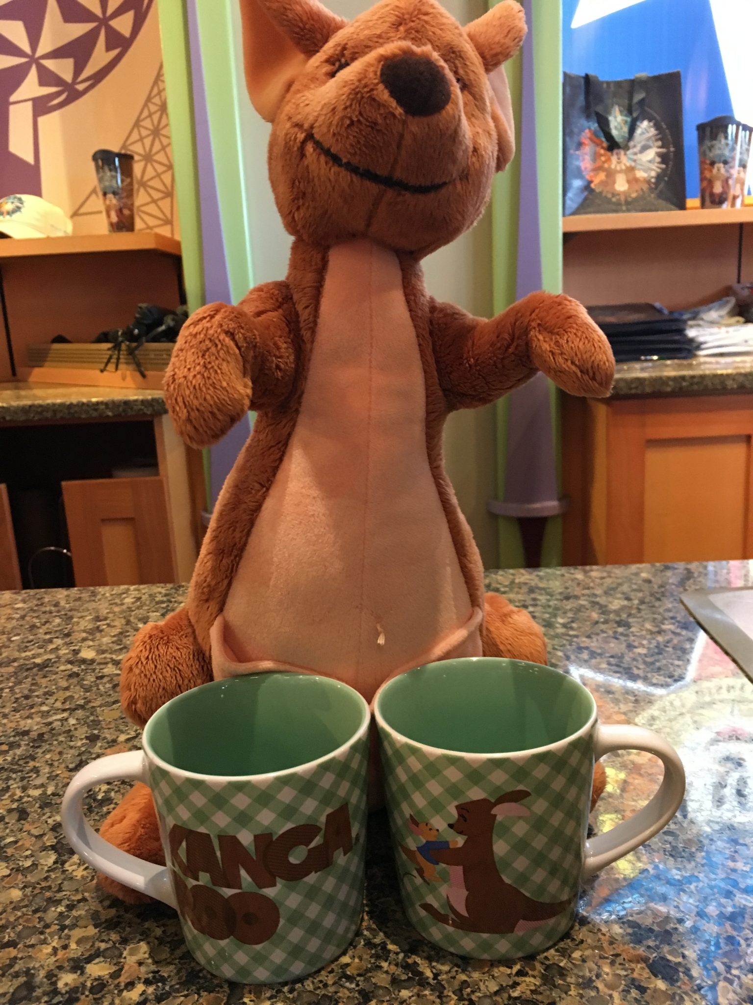 A stuffed Kanga with Kanga and Roo coffee mugs in World of Disney.
