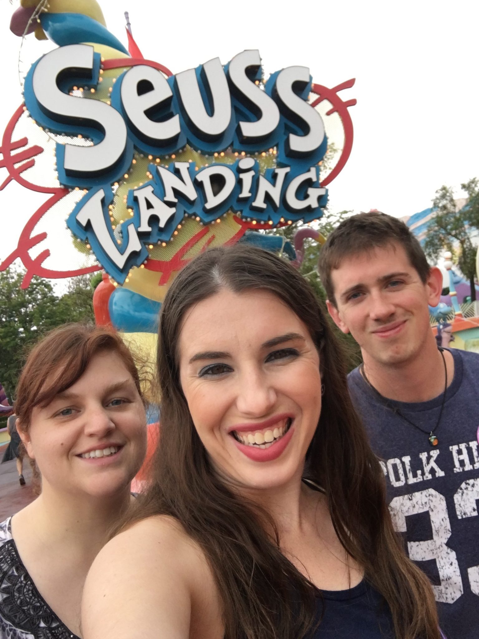 Chelsea, Robby, and Lacey in front of the Seuss landing sign.