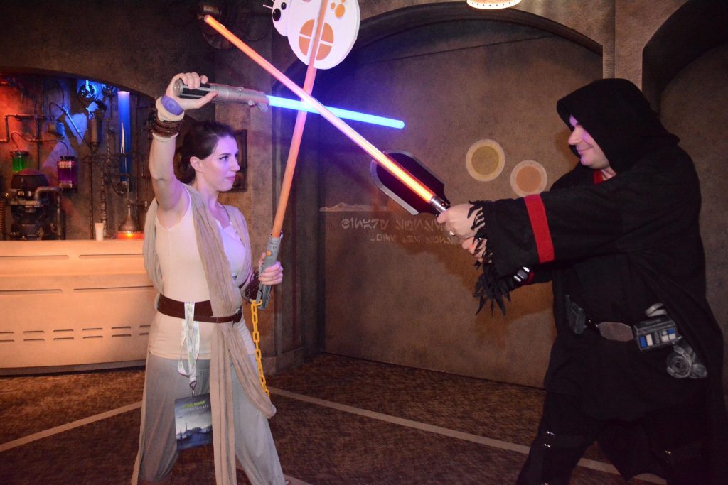 Jay and Chelsea fighting inside Star Wars Launch Bay during Galactic Nights.